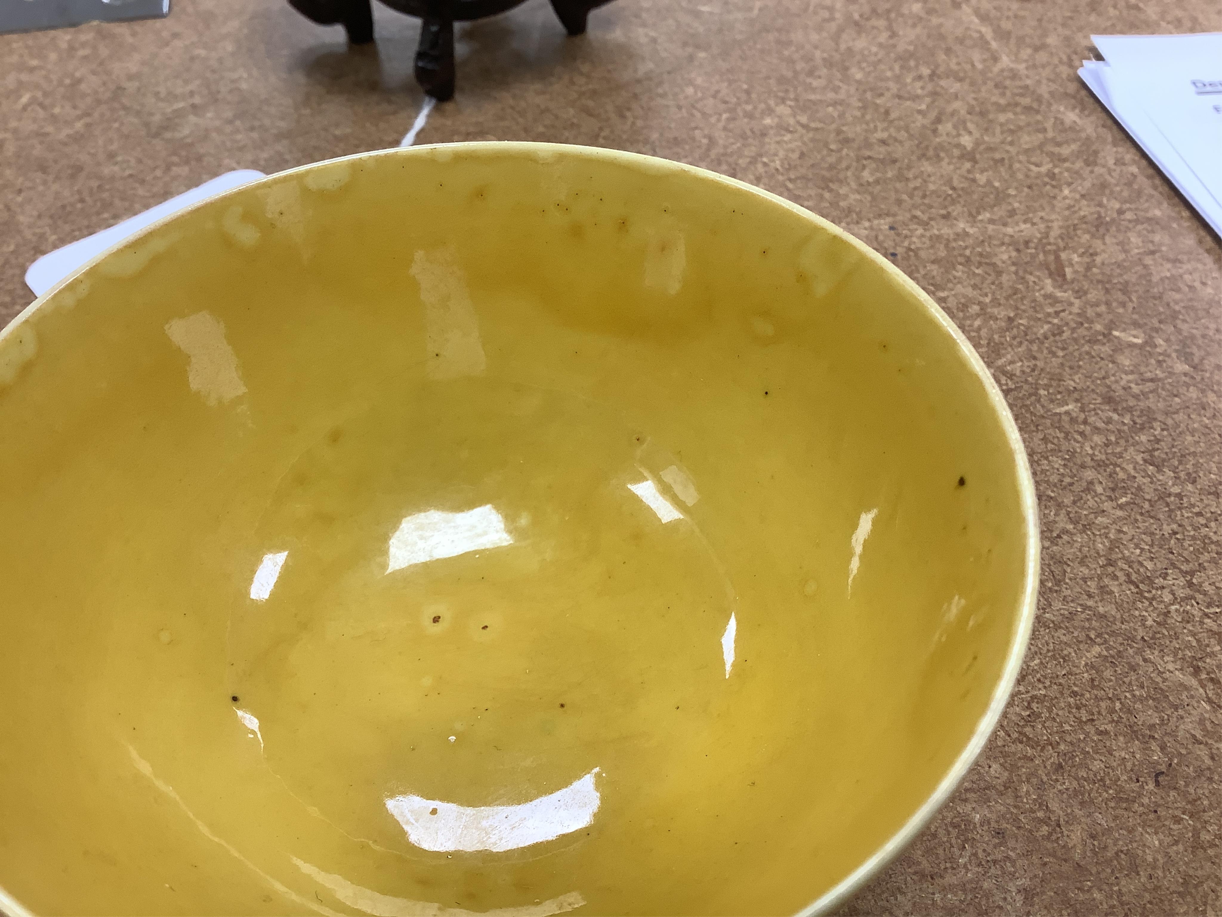 A Chinese yellow glazed teabowl on hardwood stand, 9cm diameter. Condition - fair